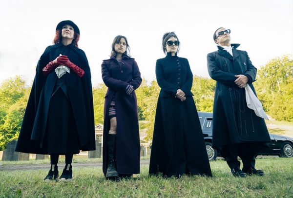 Four characters standing in a cemetery, wearing all-black outfits. From left-to-right: Catherine O'Hara as Delia Deetz, Jenna Ortega as Astrid Deetz, Winona Ryder as Lydia Deetz and Justin Theroux as Rory in "Beetlejuice Beetlejuice";