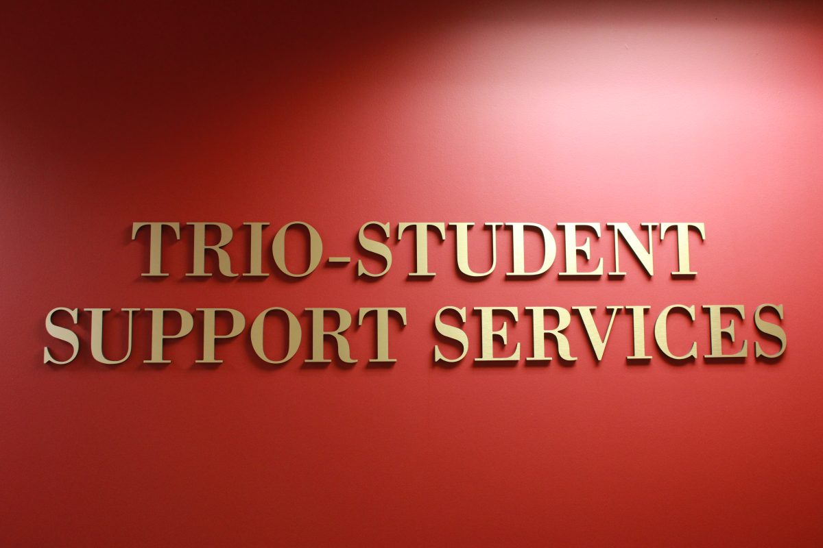 Trio-Student Support Services in gold letters on a red wall.