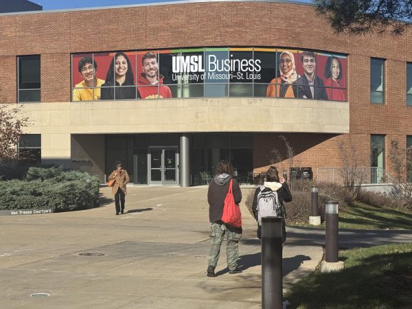 UMSL Buisiness building with students and faculty walking nearby.