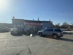 convenience store and parking lot with cars parked in front