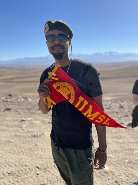 Davis holding a UMSL flag while studying abroad in Morocco