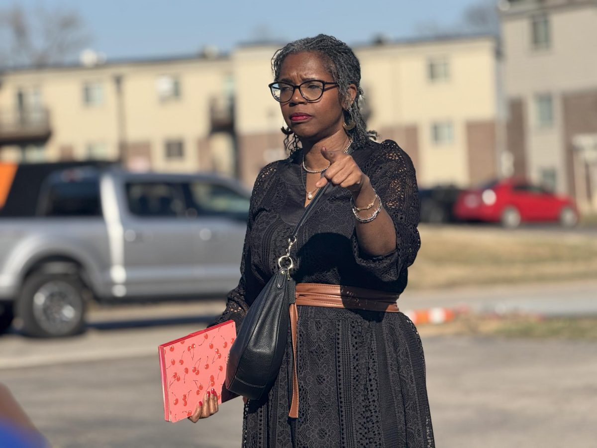 woman standing and pointing toward group behind camera