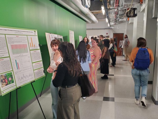 Jermey Howard Students walking through the MEEC with poster boards and presenters