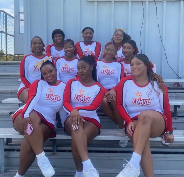 10 squad members in UMSL uniforms sitting on the bleachers. 
