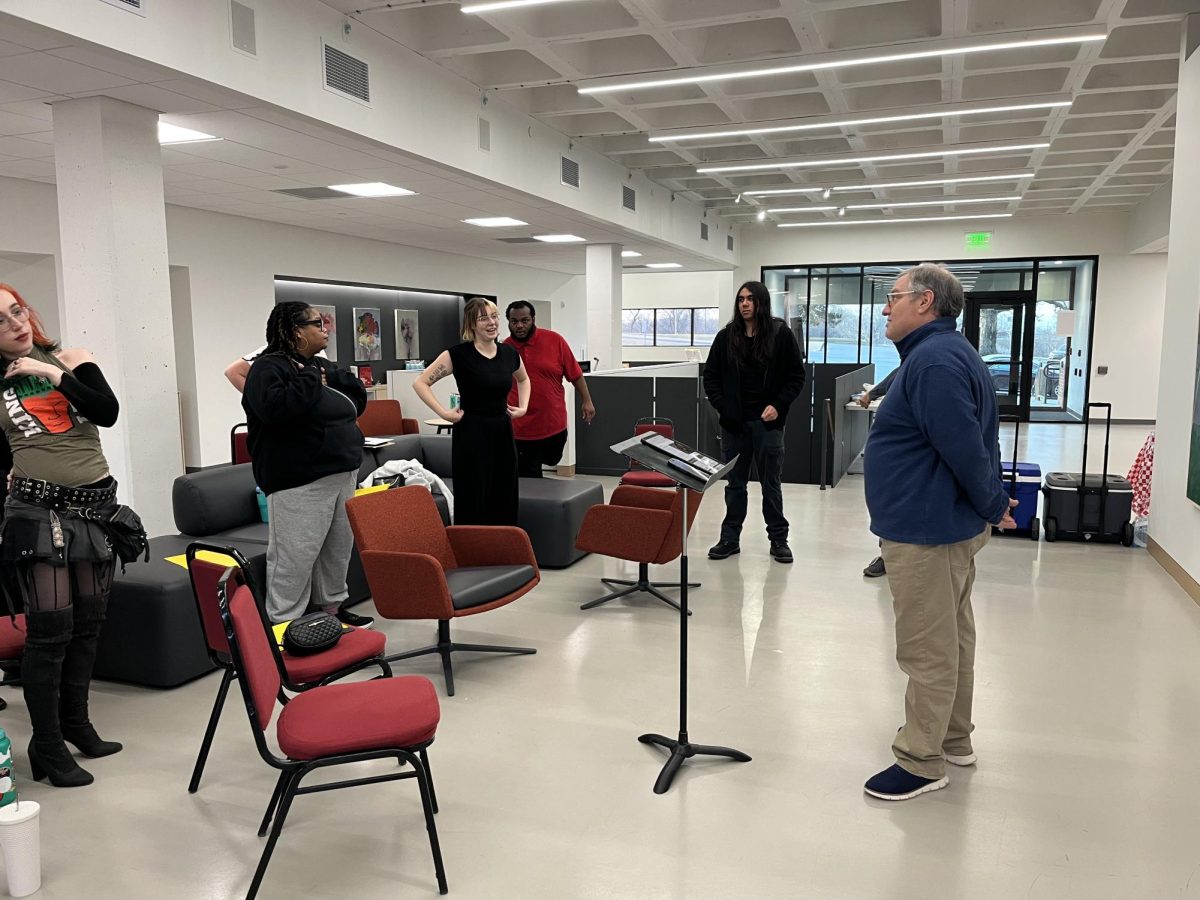 Students and director Dr. Jim Henry engage in physical warmups and conversation.