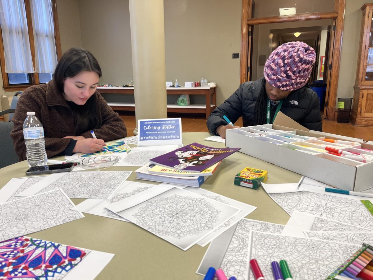 Students color intricate pictures at the event's coloring station. 