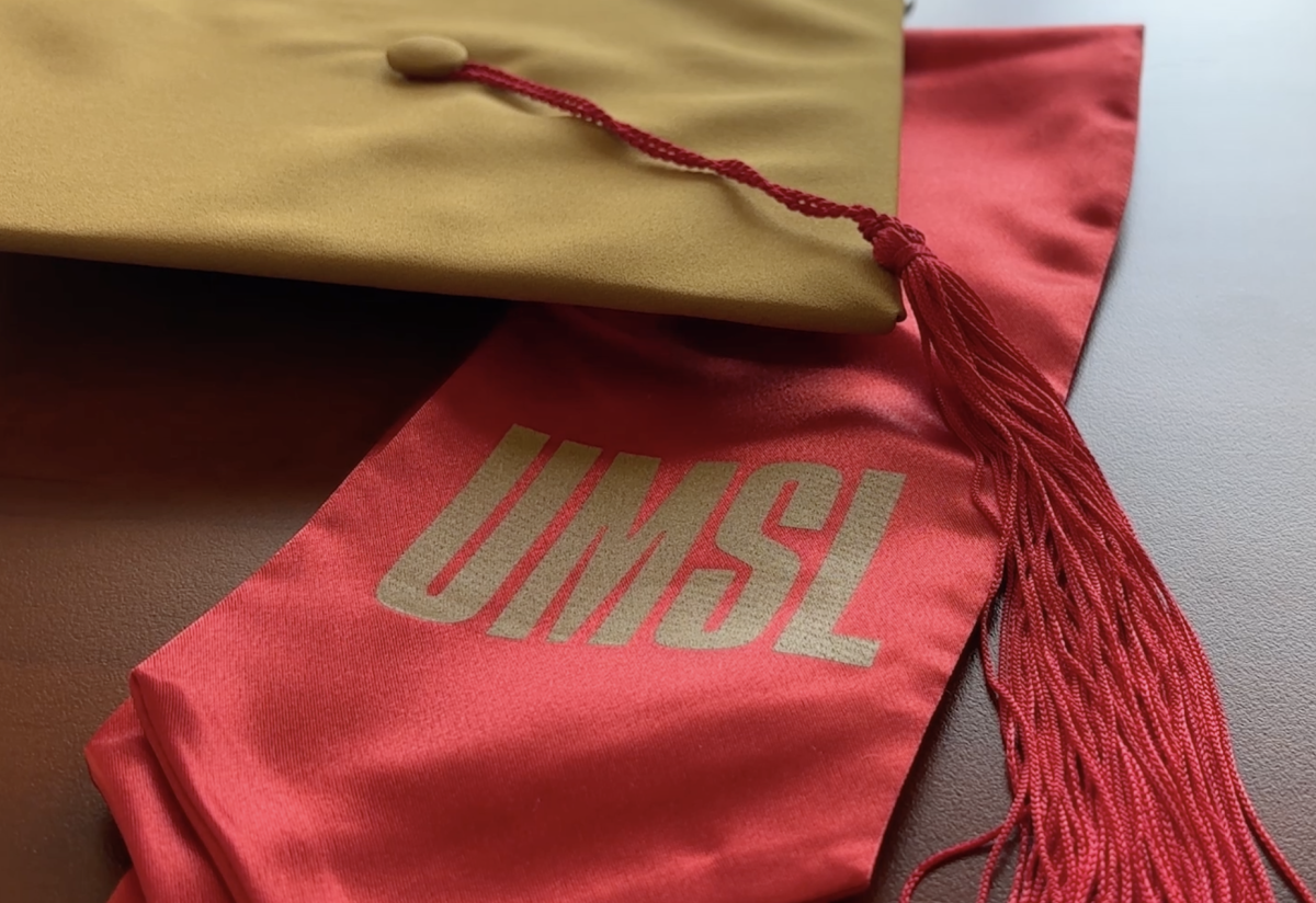 Golden grad cap and UMSL red stole